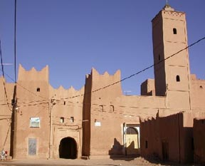 Big door and minaret of the mosque in Ksar El Khorbat.